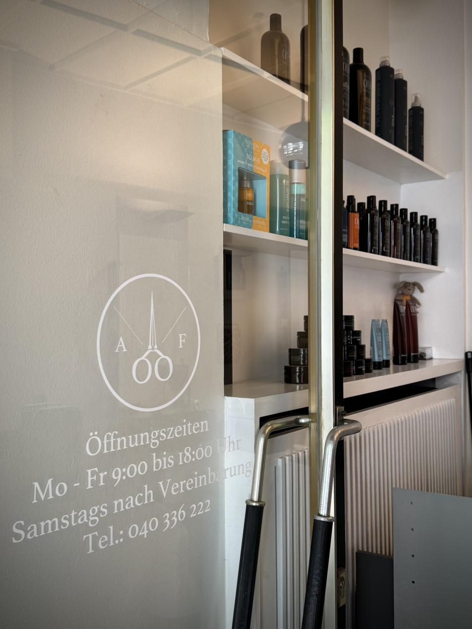 Eingangstür mit graviertem Altstadt Friseure Logo und Öffnungszeiten