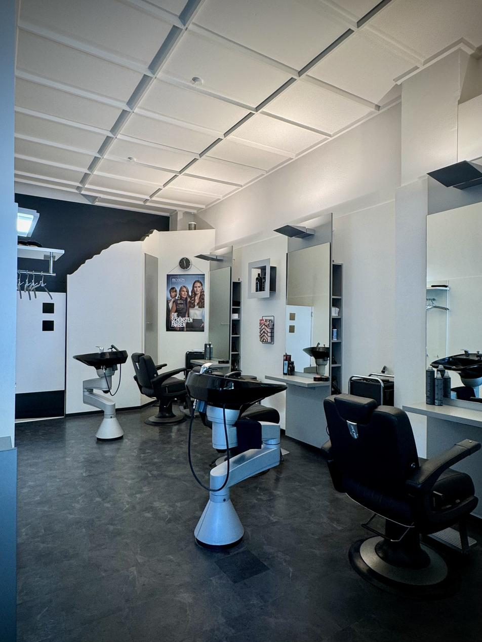 Blick in den Salon mit Friseurstühlen und Spiegeln